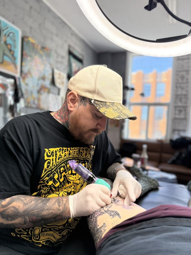 Trevor Moran tattooing a client at Stingray Tattoo in Regina